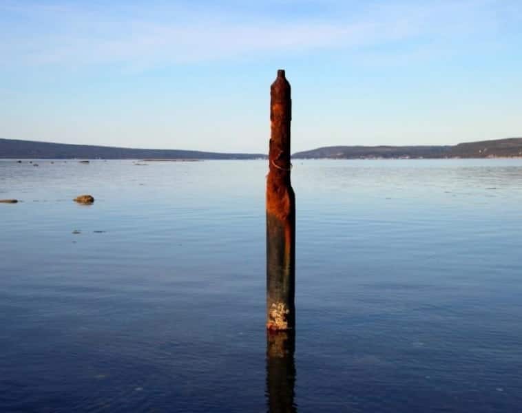 An abandoned oil well-head believed to be leaking oil sticks out of the water at Shoal Point in Port au Port Bay..